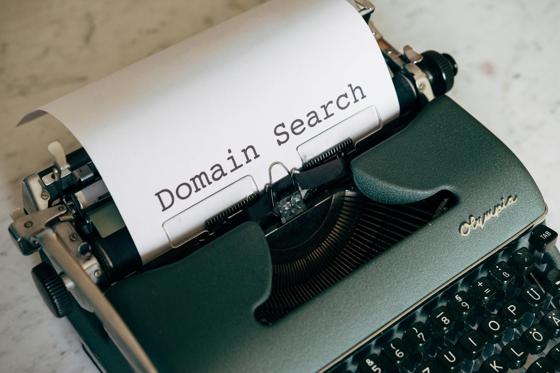 A typewriter with a sheet of paper displaying 'Domain Search